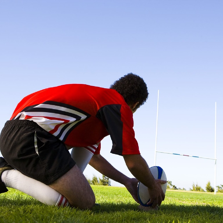 Rugby player by goal post