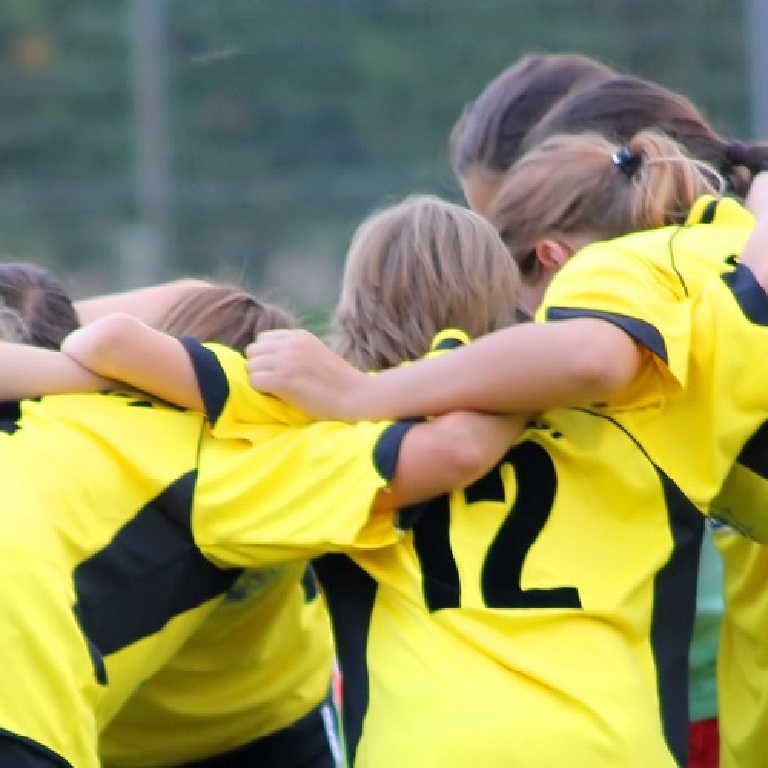 Women's football team huddle before the game