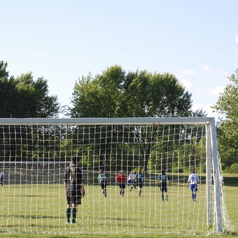 Teenagers playing football on a local pitch