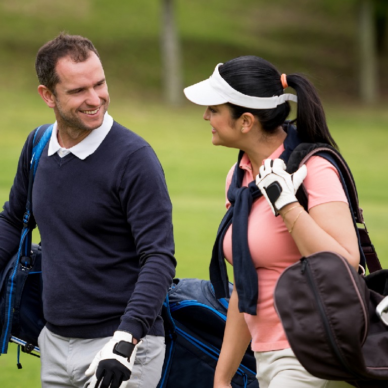 Portrait of a couple of golfers playing together and carrying their own bags