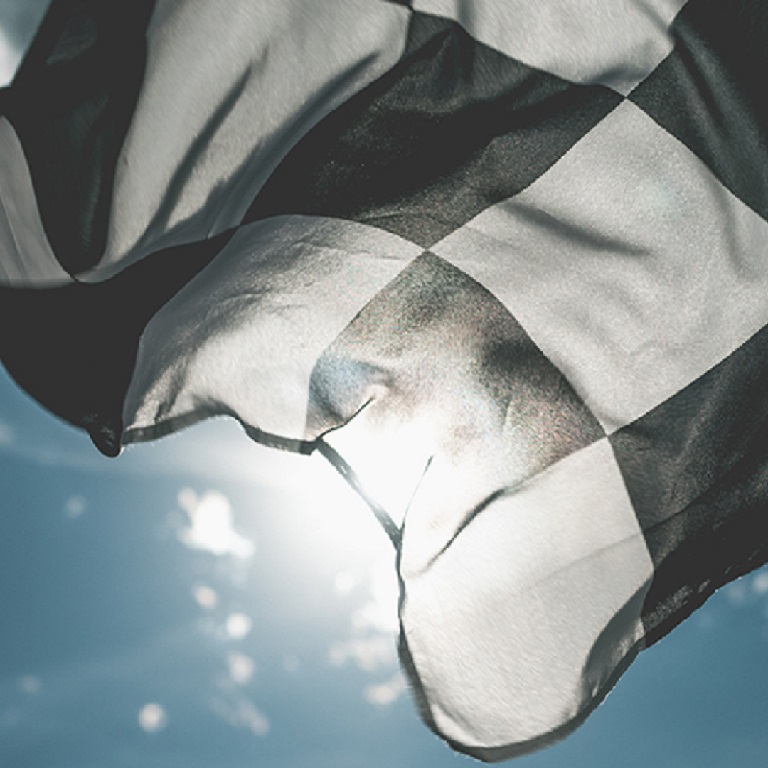 Checkered flag waving in front of sunny sky